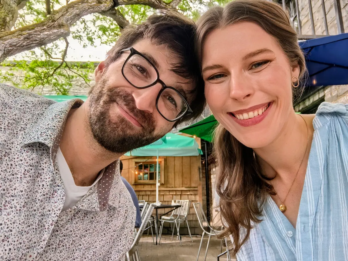Goldwin and Holly, the two founders of Limestone Web Studio, heads together and smiling on a patio in Kingston